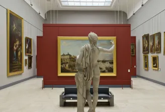 Galleria del Museo delle Belle Arti di Bordeaux con una statua in marmo in primo piano di fronte a dipinti storici con cornici dorate su pareti bianche e rosso borgogna, con illuminazione zenitale.