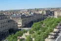 Vista aerea delle Allées de Tourny a Bordeaux con edifici in stile haussmanniano, alberi verdi e facciate in pietra.
