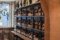 Scaffale per vini con cornici nere contenente numerose bottiglie di vino rosso e bianco in una enoteca di Bordeaux.